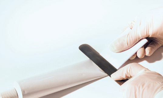 a person using a knife to cut a tube