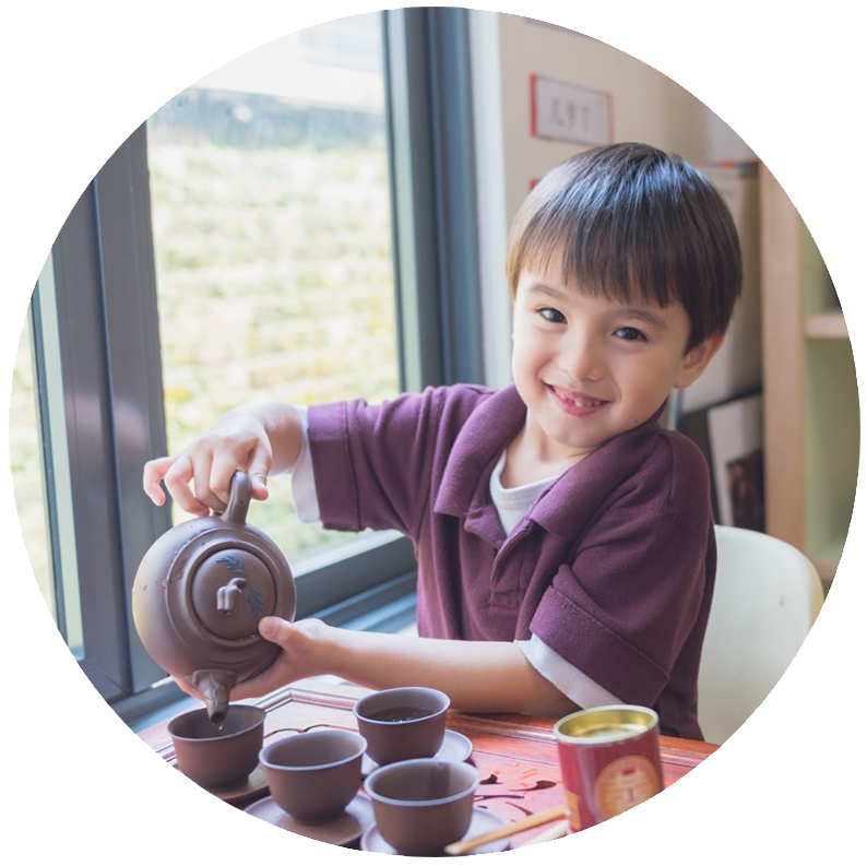 a boy pouring a teapot into cups