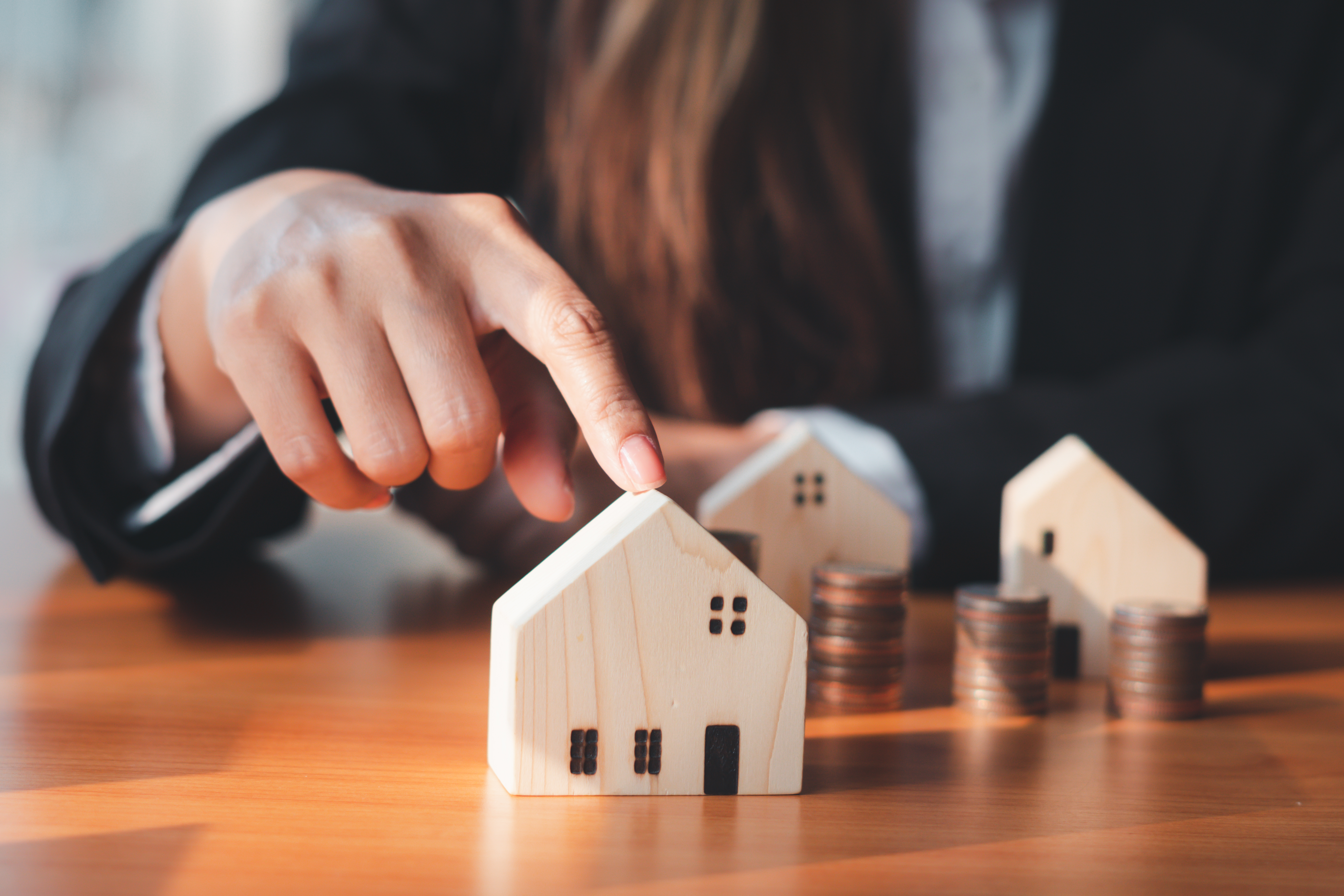 a person pointing at a small wooden house