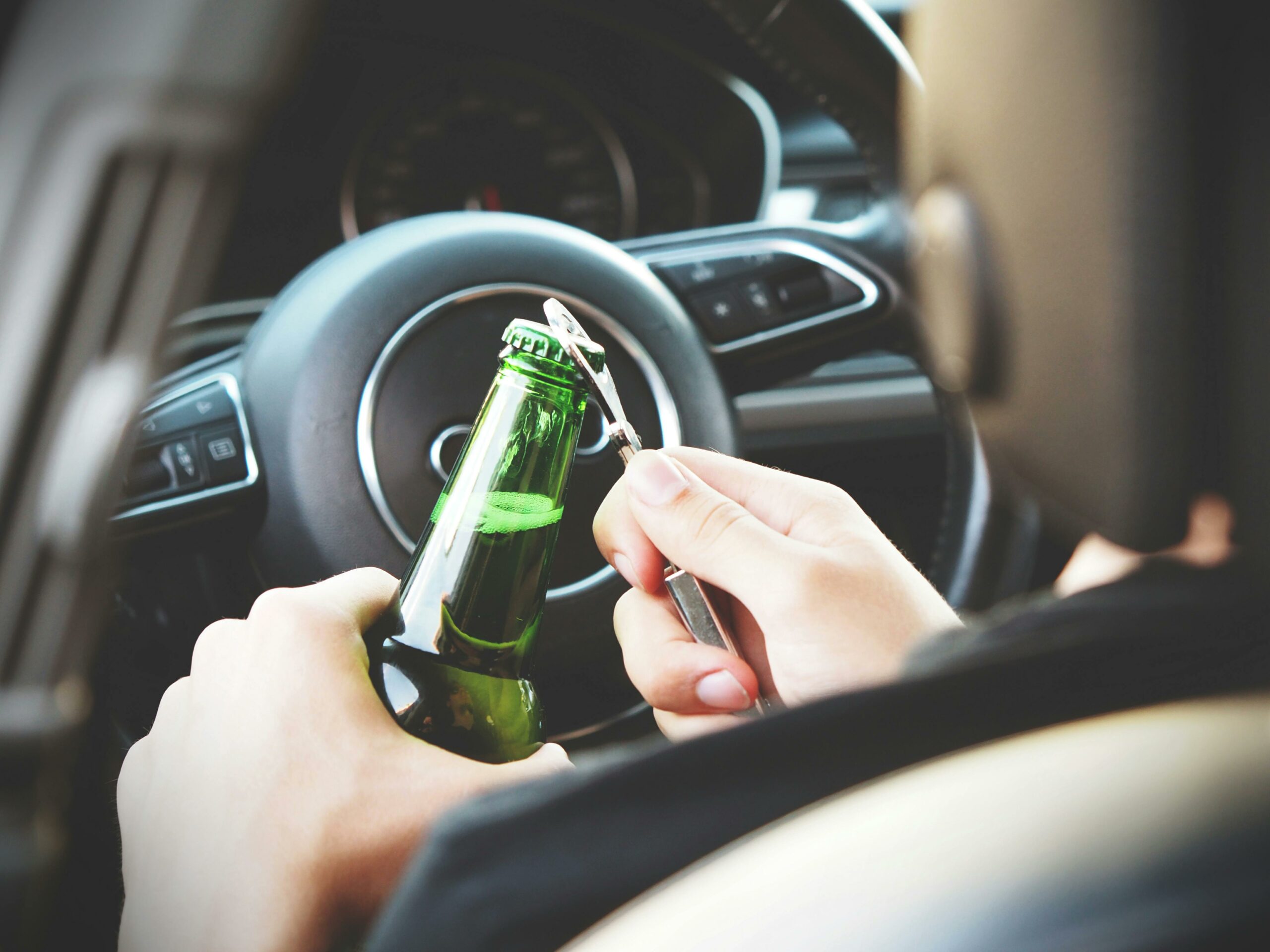 a person holding a bottle of beer in a car