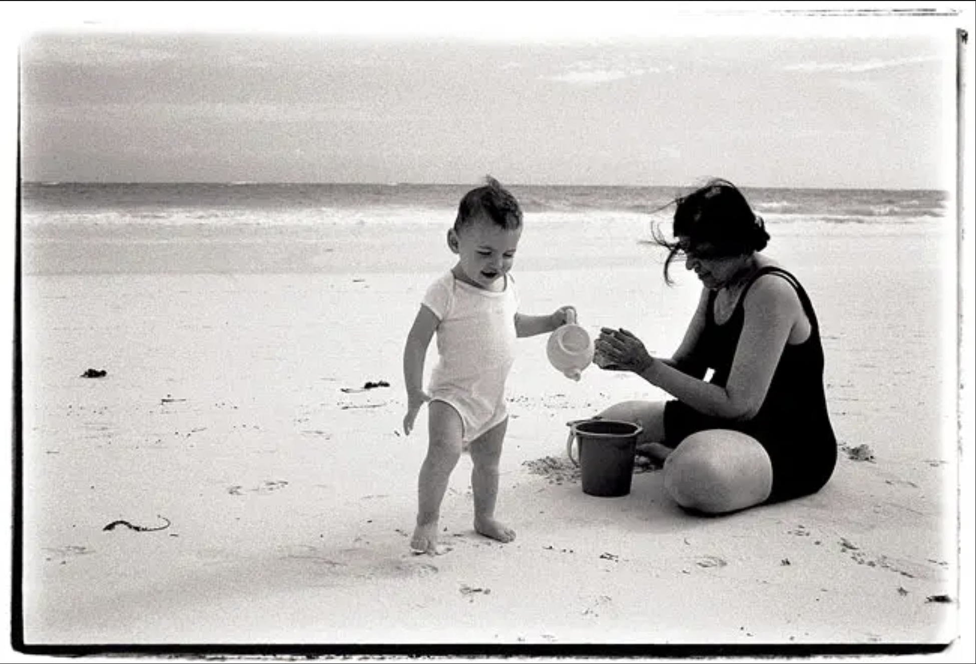 a woman and baby on a beach