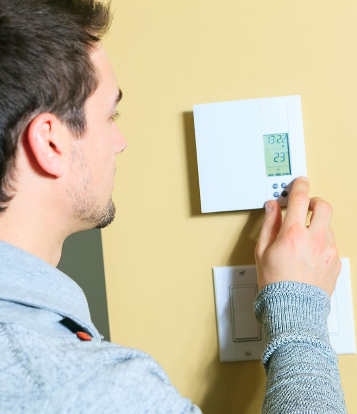 a man setting up a thermostat