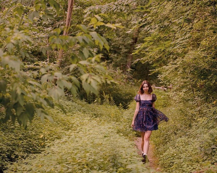 a woman walking on a path in a forest