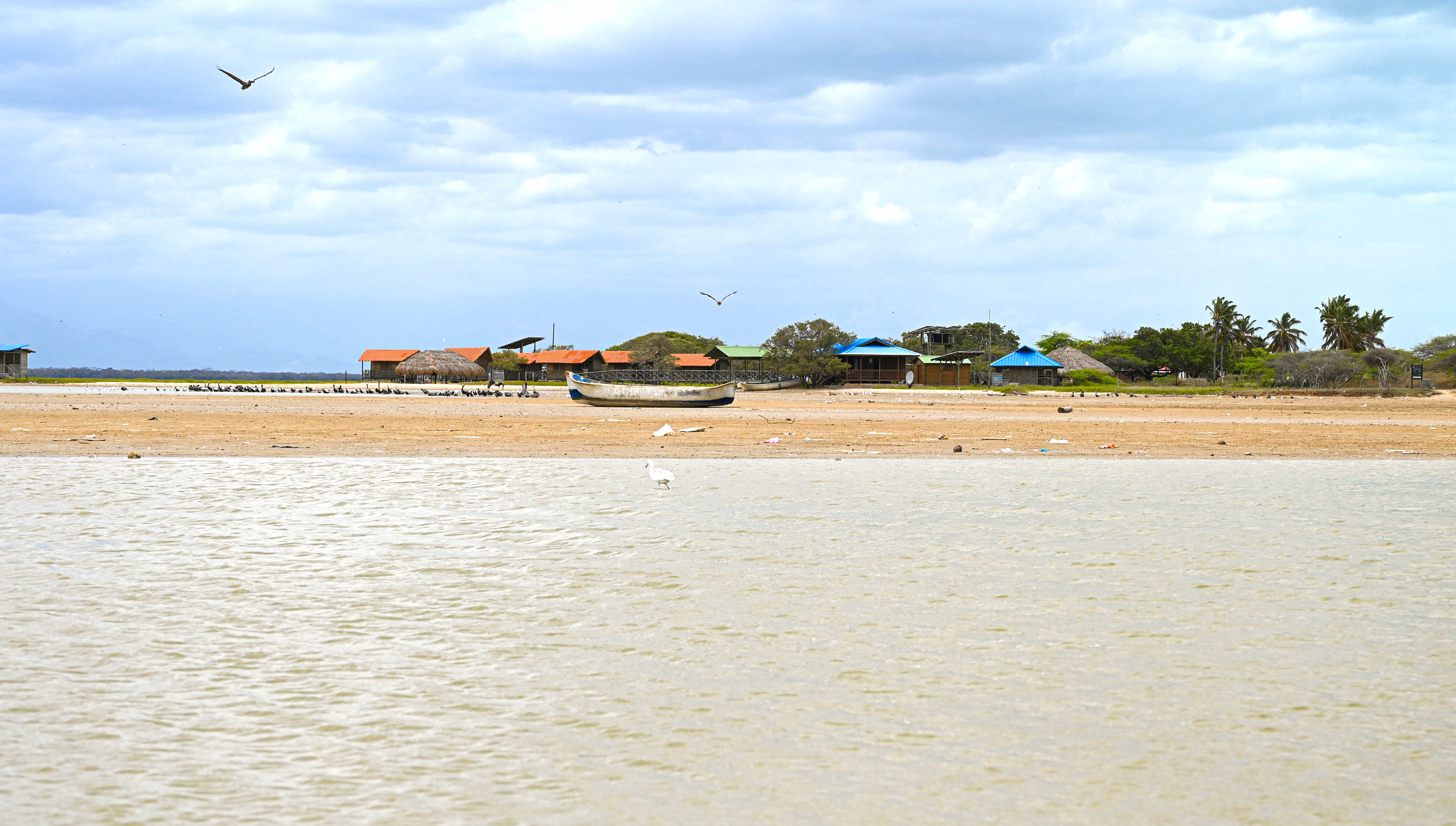 a beach with a boat and buildings in the background