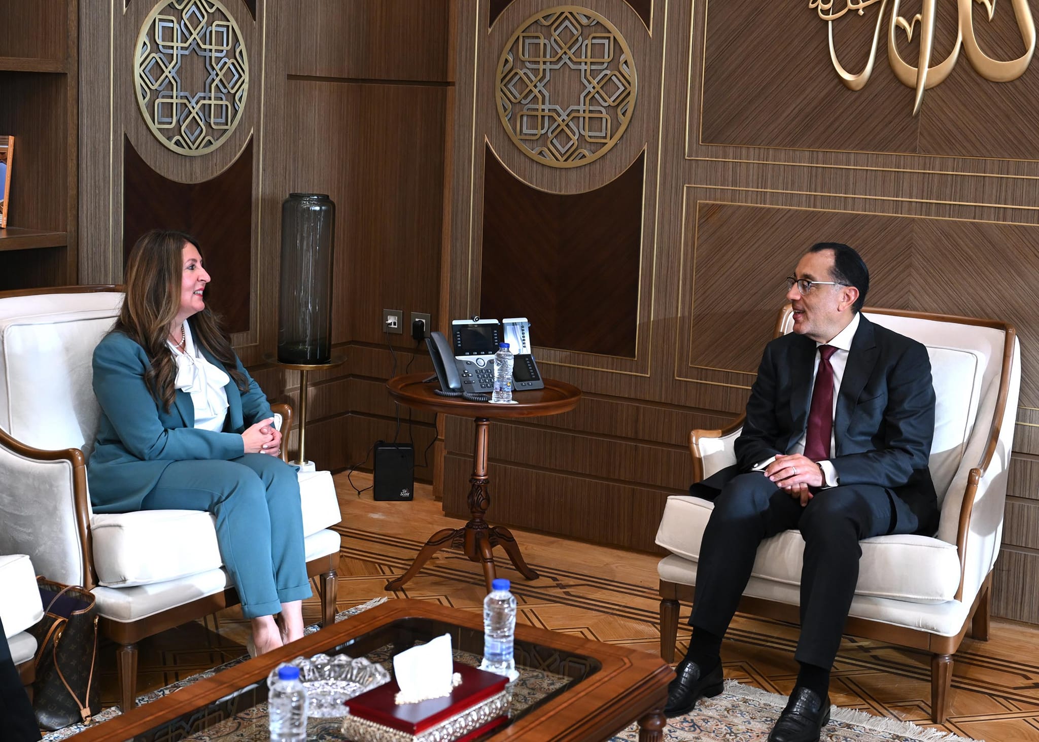 a man and woman sitting in chairs talking