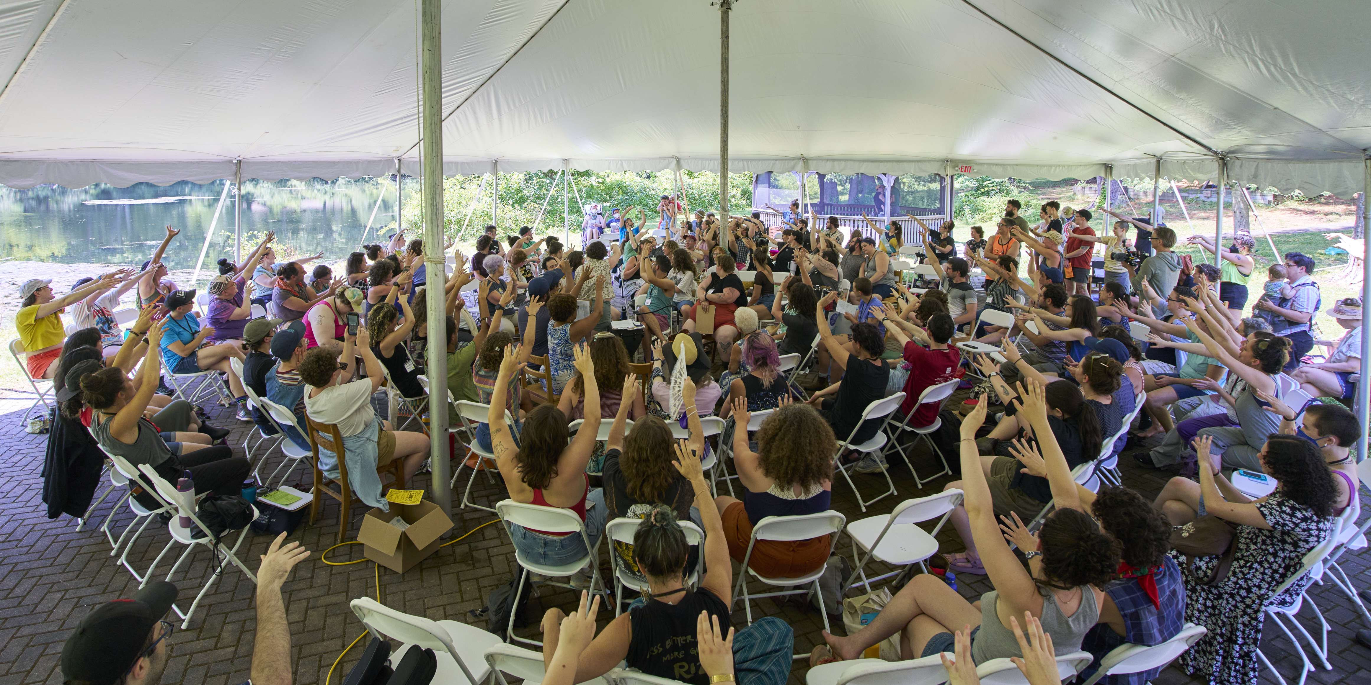 a group of people sitting in chairs under a tent