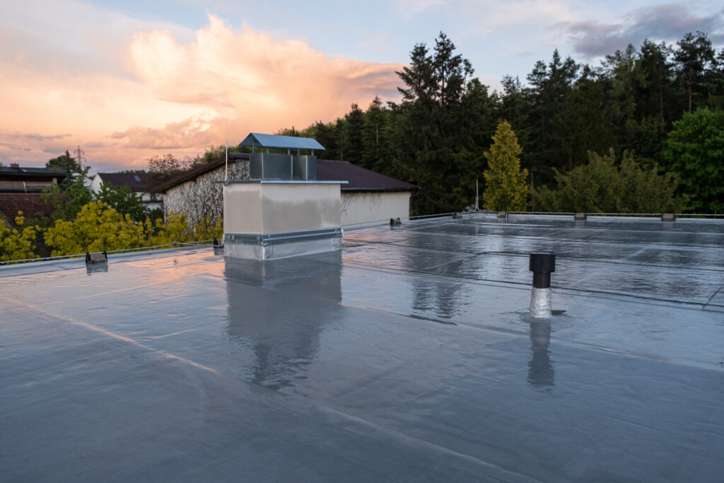 a roof with a chimney and trees in the background