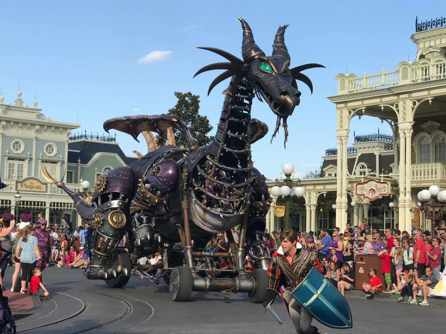 a man in a garment riding a dragon on wheels