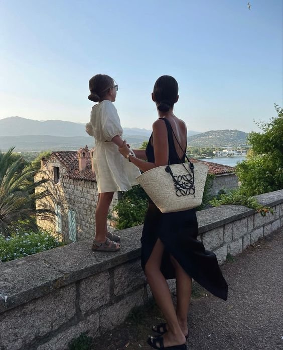 a woman and a child standing on a stone wall