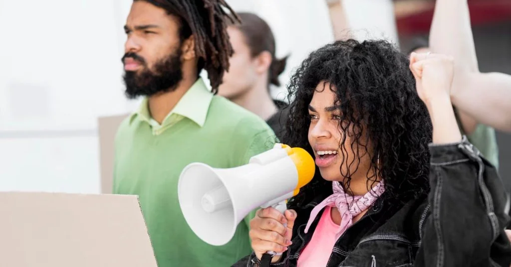 a woman holding a megaphone with a man behind her