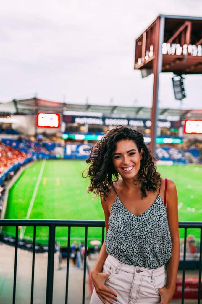 a woman standing on a railing in a stadium