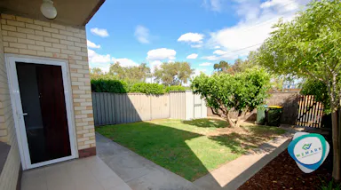 a backyard with a fence and a tree
