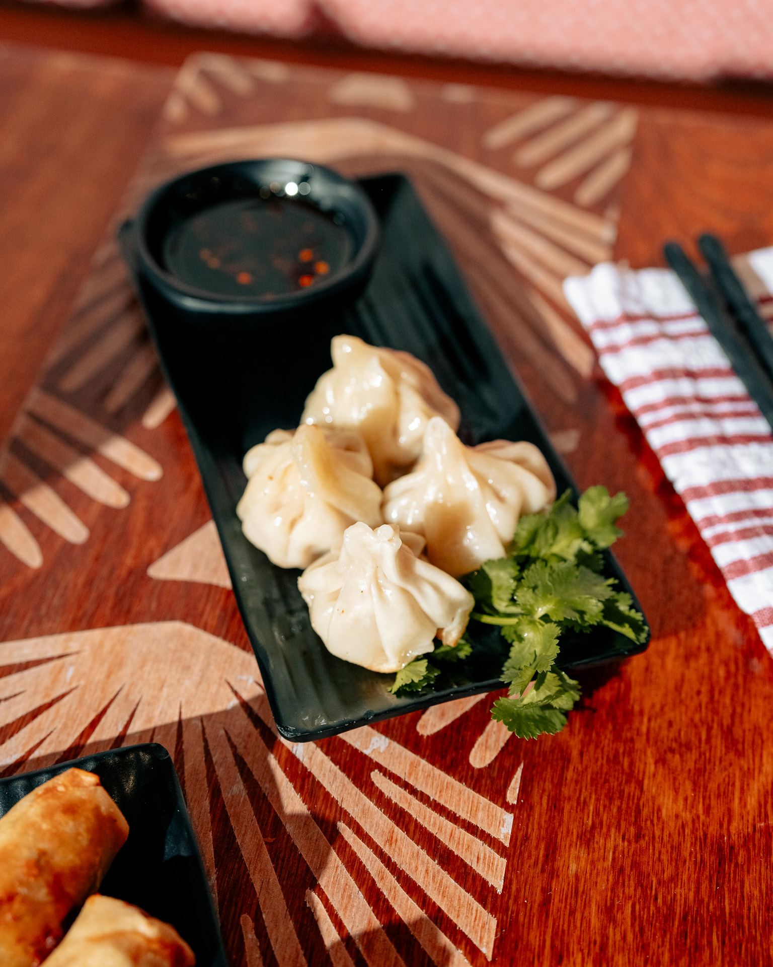 a plate of dumplings and sauce on a table
