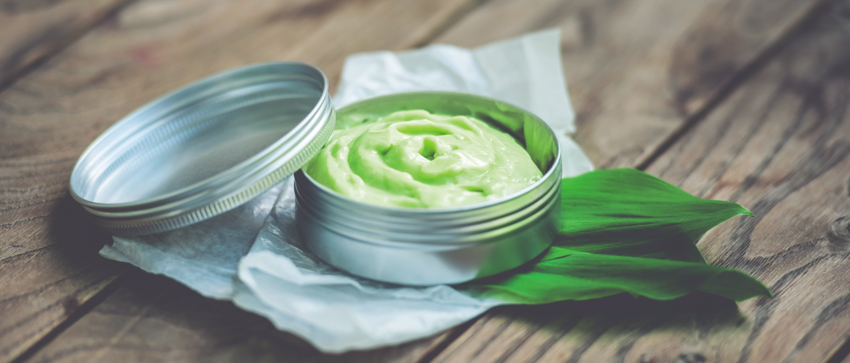 a jar of cream on a leaf