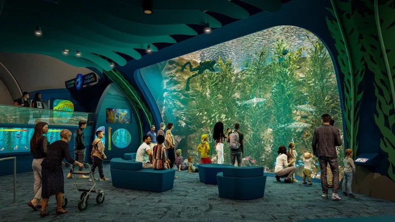 people in a room with a large aquarium