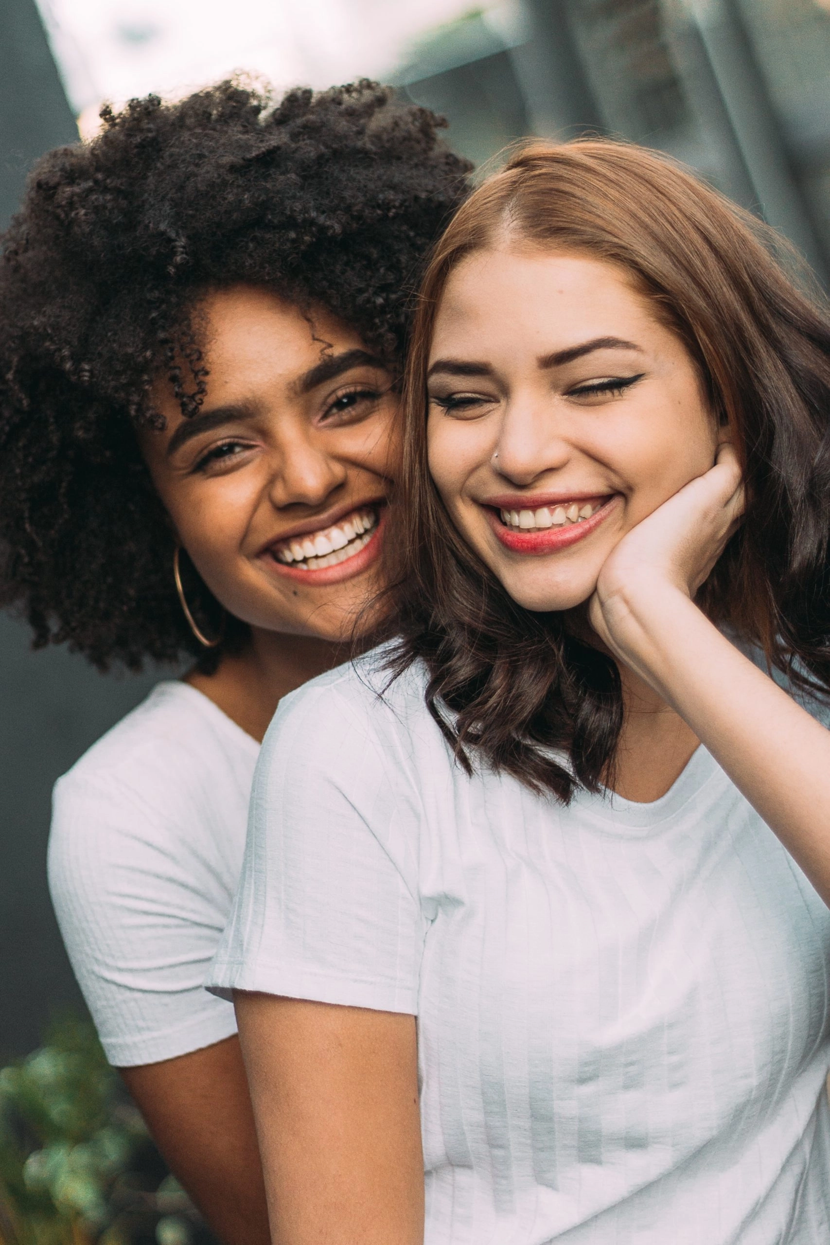 two women smiling and hugging each other