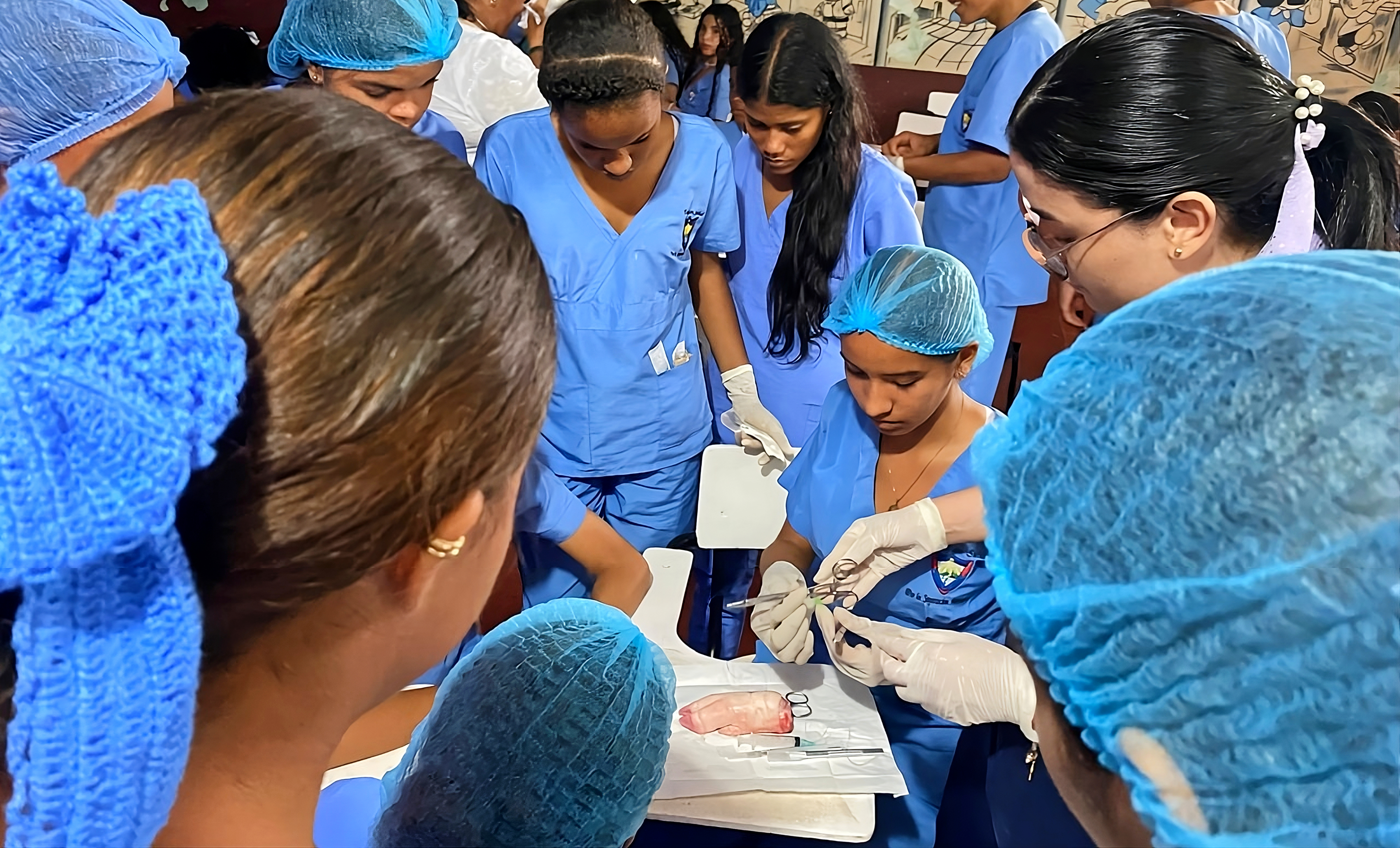 a group of people wearing blue scrubs and gloves