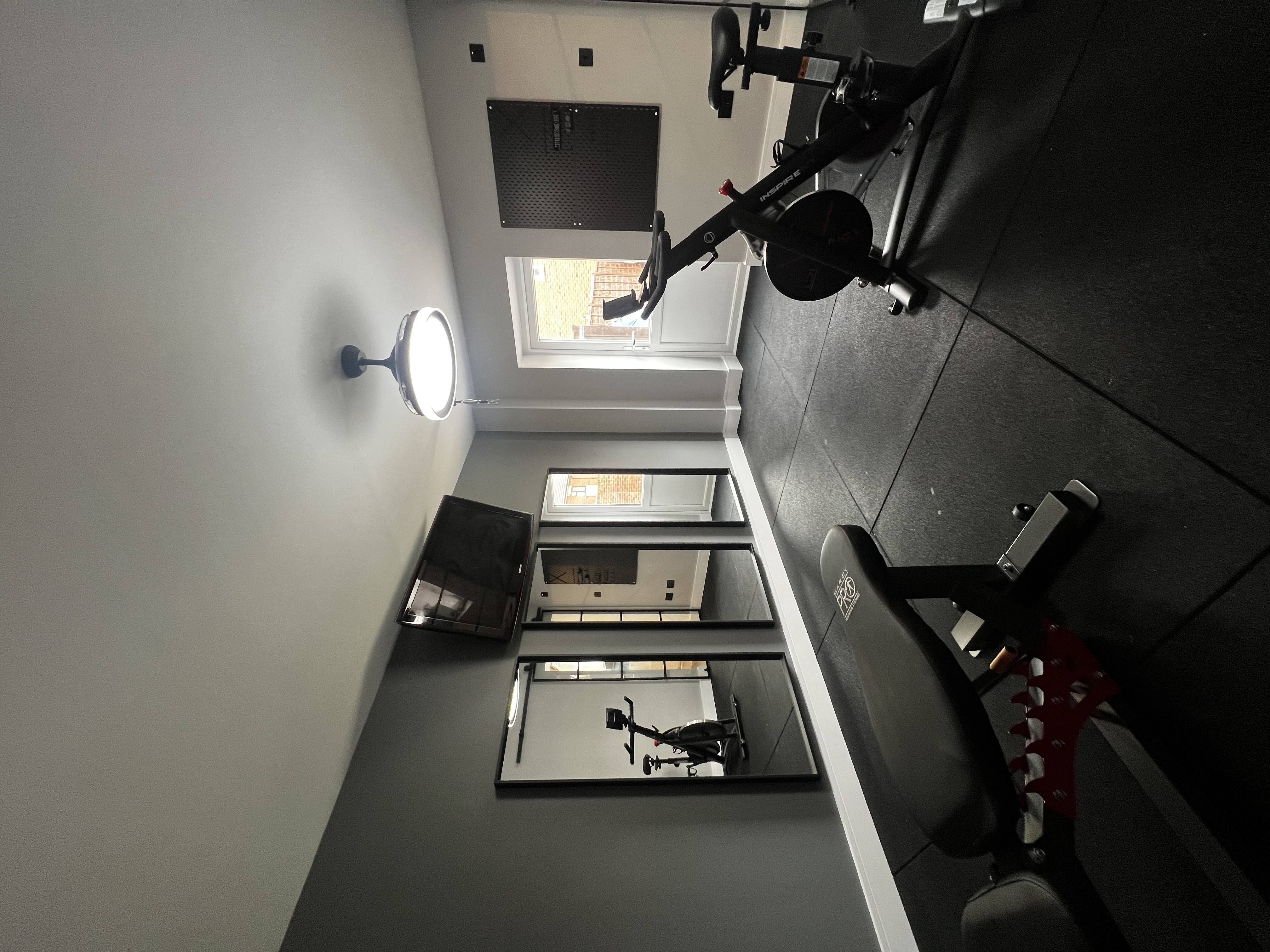 a gym with exercise bikes and a mirror