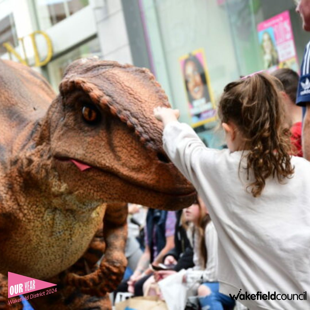 a girl touching a dinosaur