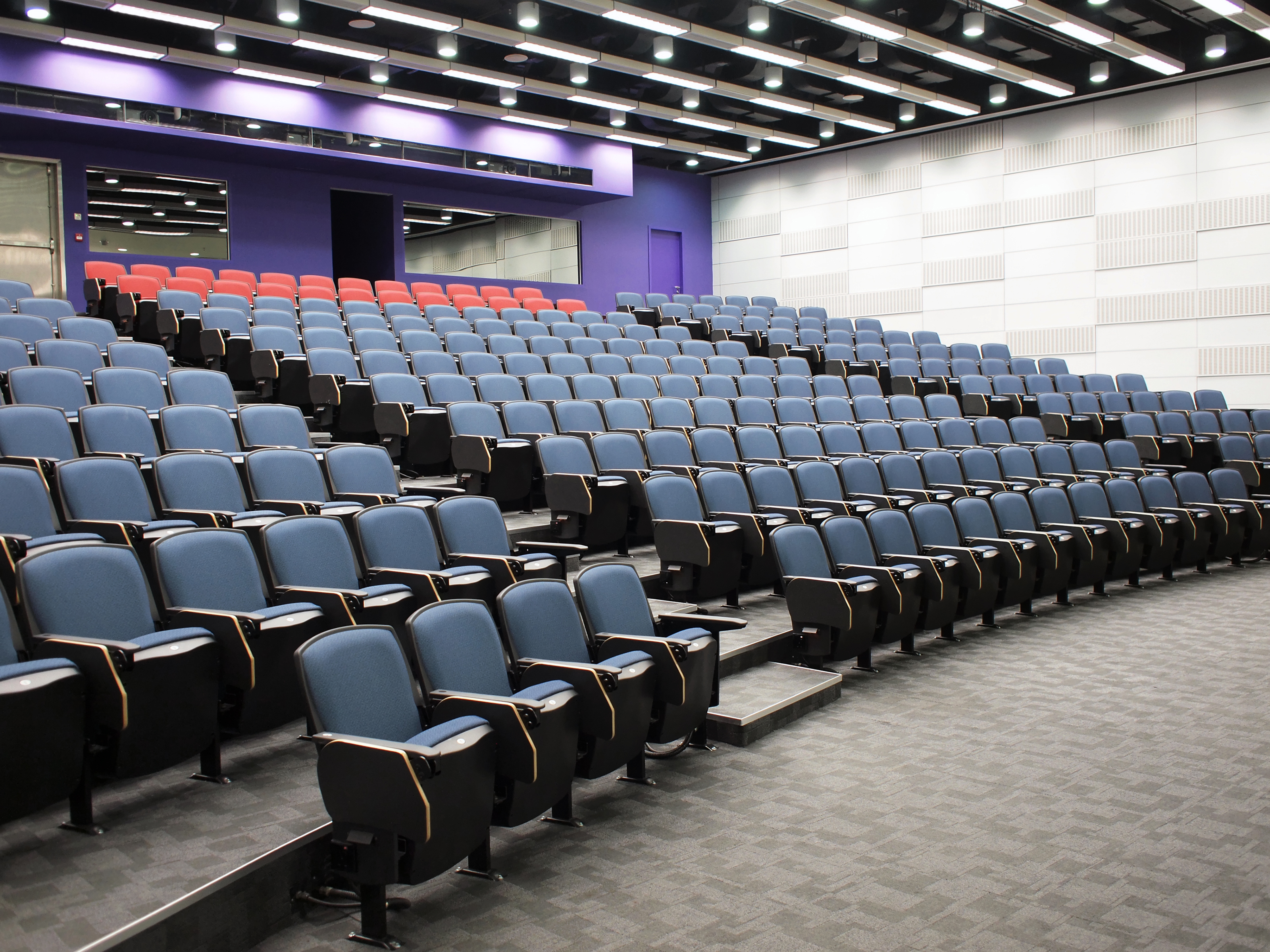 a large auditorium with rows of blue and red seats