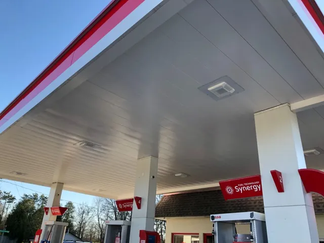 a gas station with a red and white roof