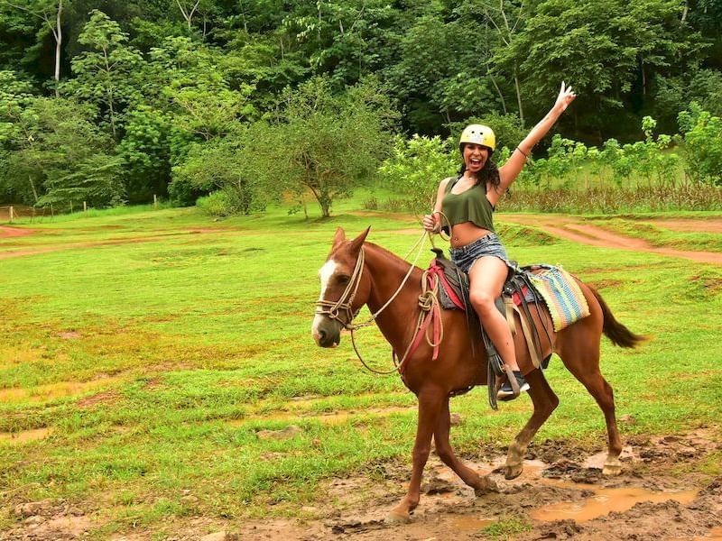 a woman riding a horse in a mud puddle