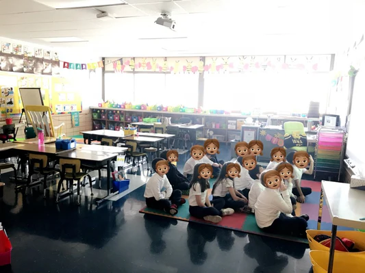 a group of people sitting on the floor in a classroom