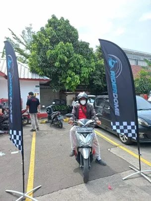 a person on a motorcycle with a mask and flags