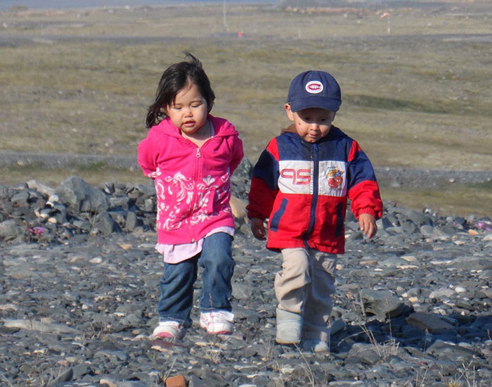 a couple of children walking on rocks