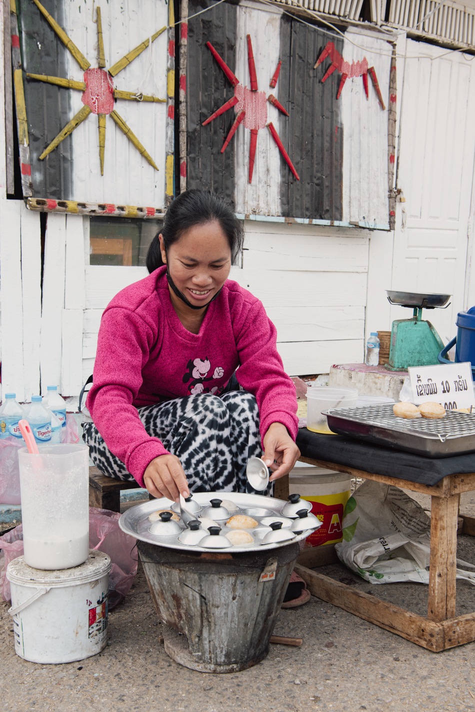 a woman sitting outside cooking food