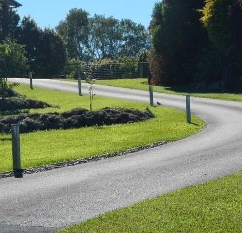 a winding road with grass and trees