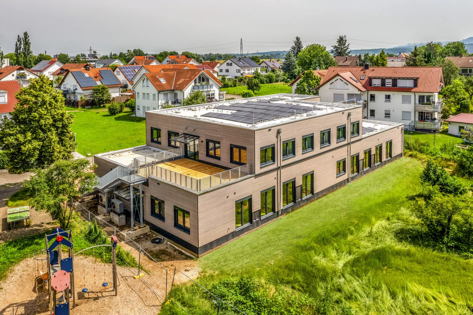 a building with a roof and a yard with a grass field