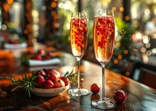 two glasses of champagne with berries on a table