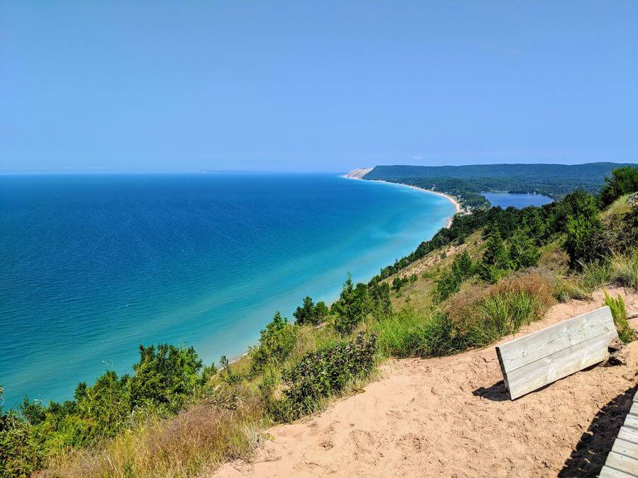 a bench on a hill overlooking a body of water