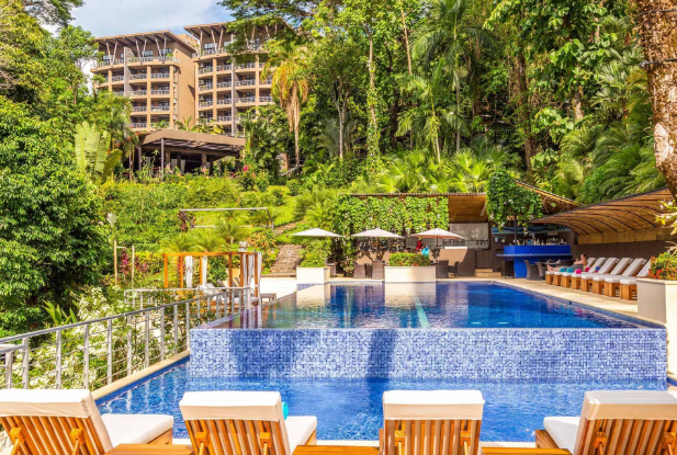 a pool with chairs and trees around it