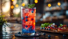 a glass of blue and red drink with ice and berries