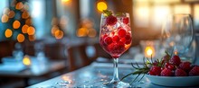 a glass of red liquid with berries and ice