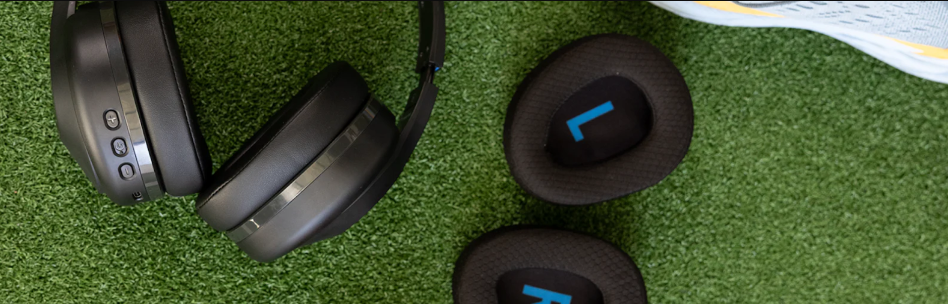 a pair of black headphones and black slippers on a green surface