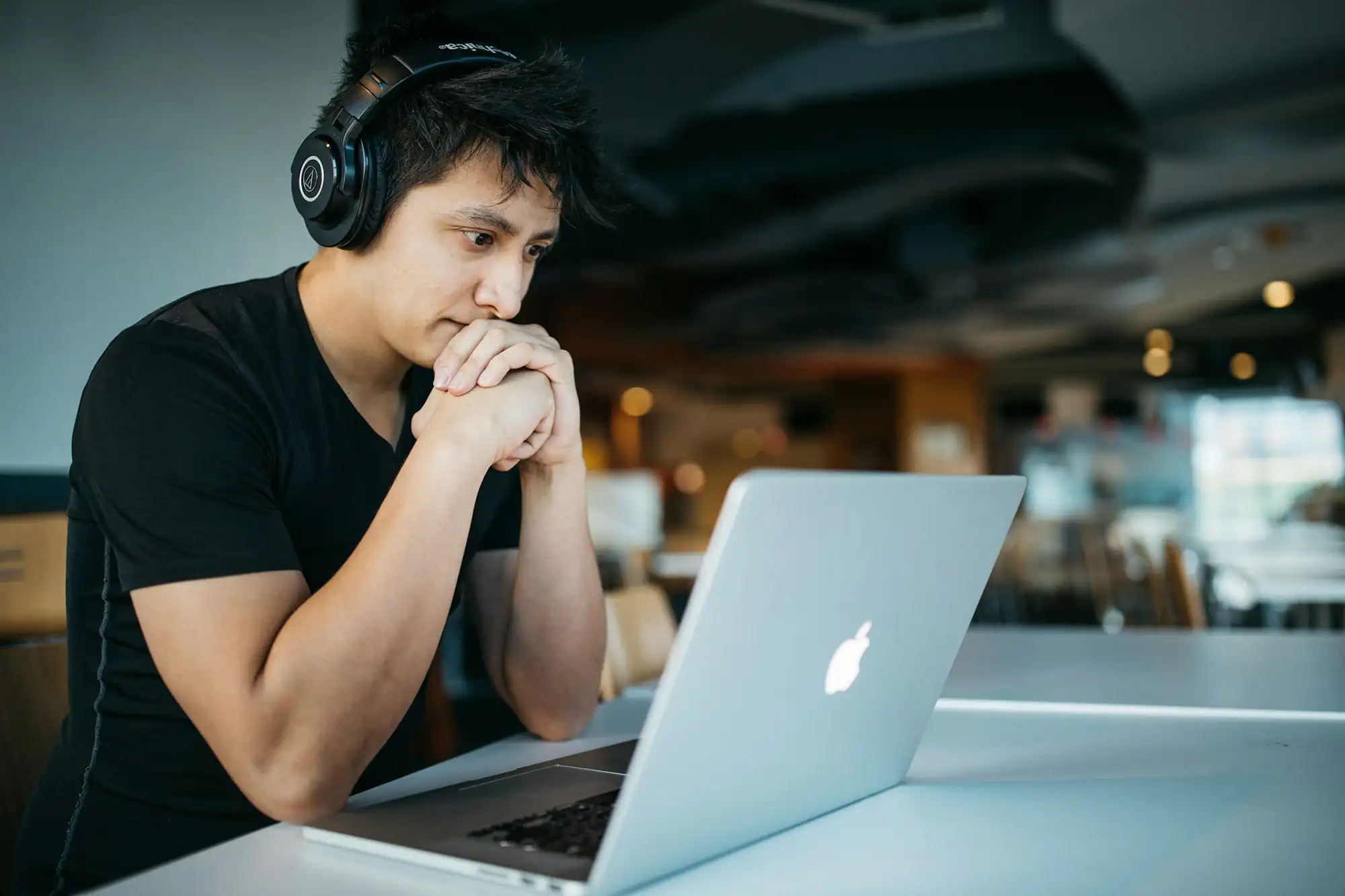 a man wearing headphones looking at a laptop