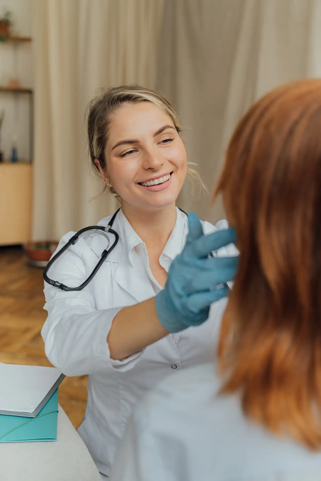 a woman wearing a white coat and blue gloves