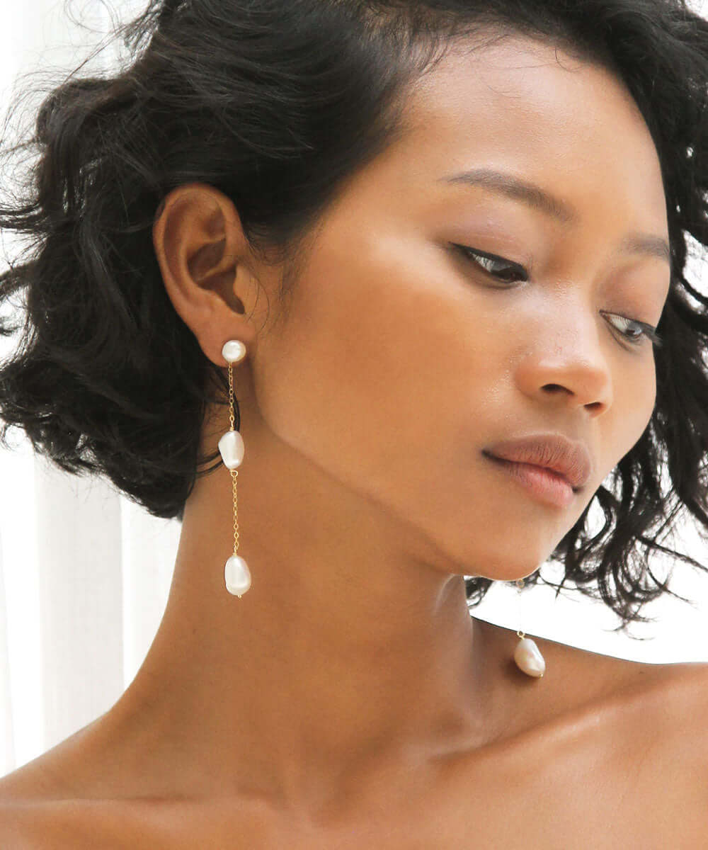 a woman with short dark hair wearing earrings