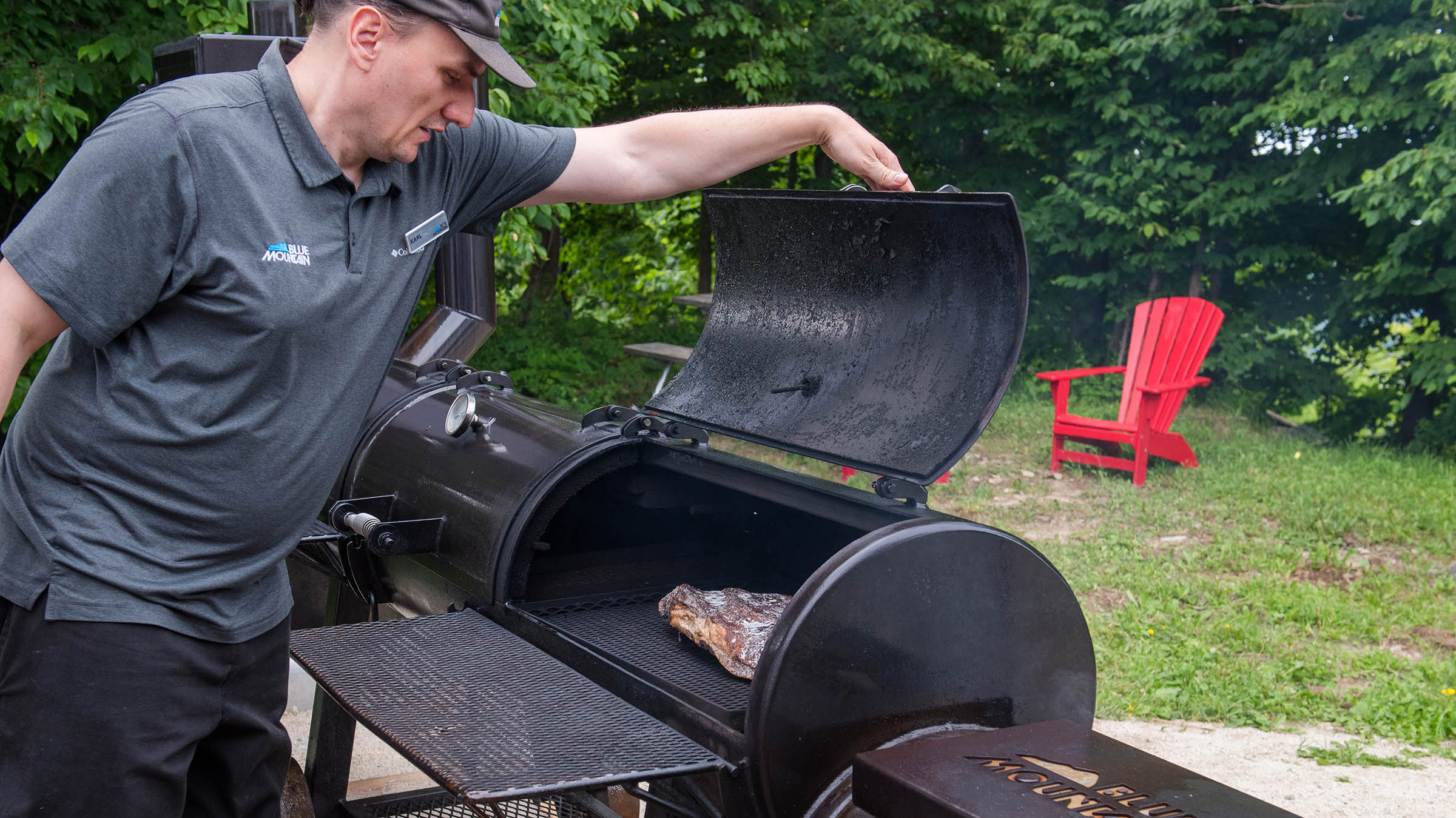 a man putting meat on a grill