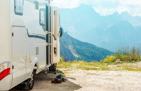 a white rv parked on a rocky mountain