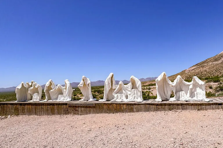 a group of white statues in a desert