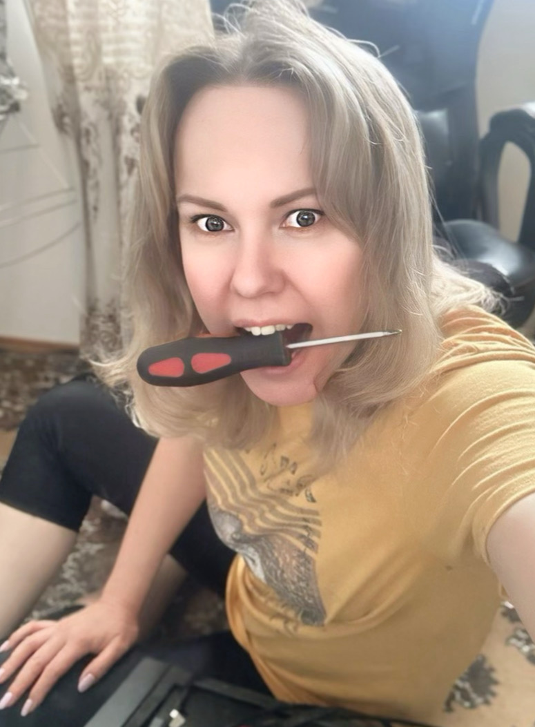 a woman holding a screwdriver in her mouth