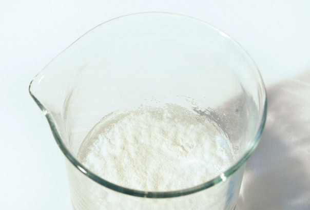 a glass beaker filled with white powder