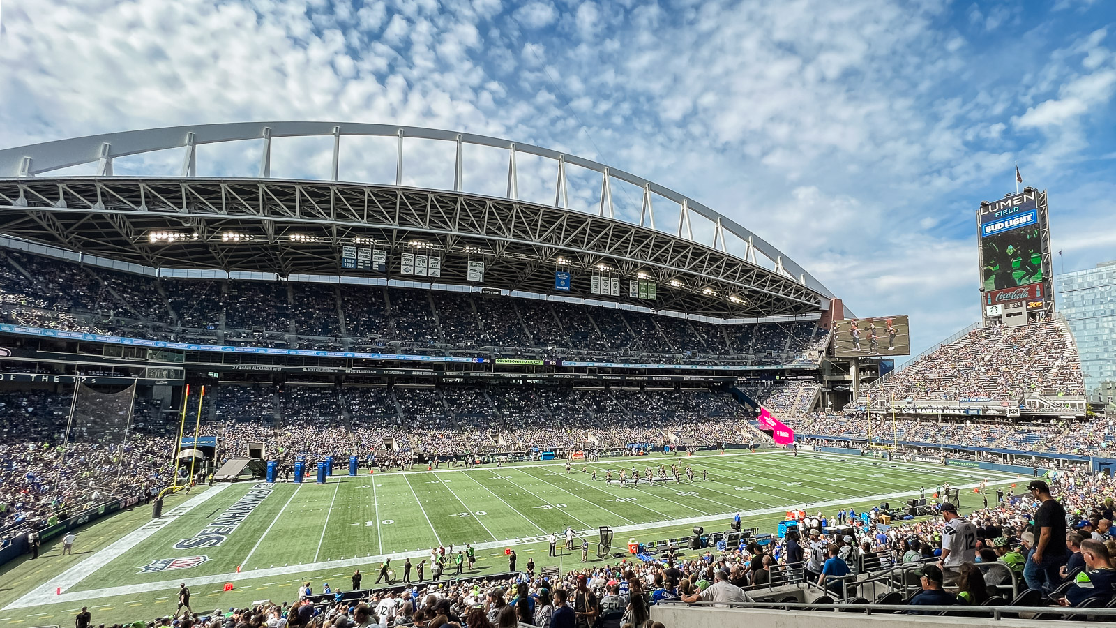 a stadium with people in the stands with CenturyLink Field in the background