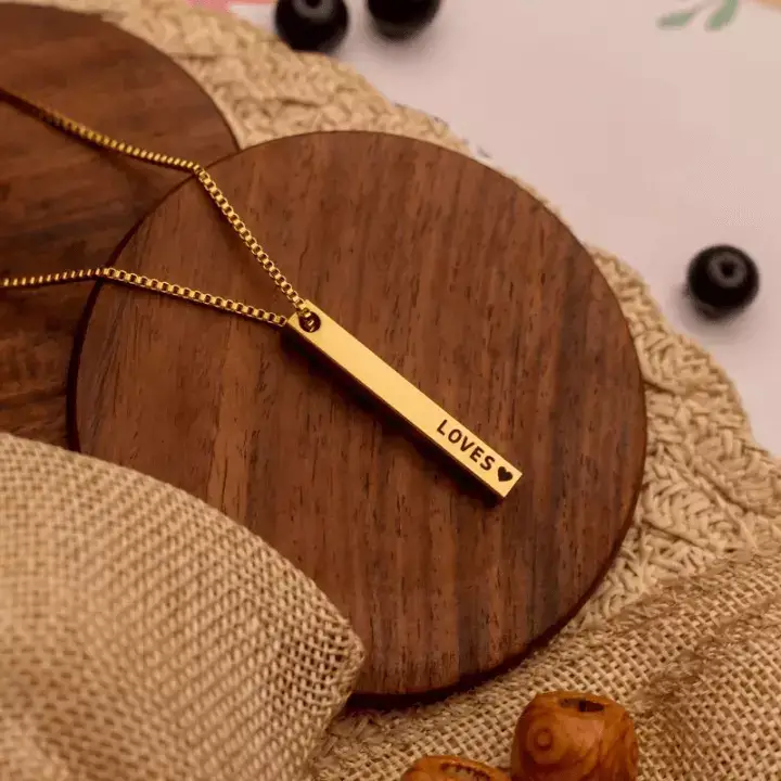 a gold necklace on a wooden surface