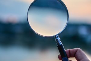 a hand holding a magnifying glass