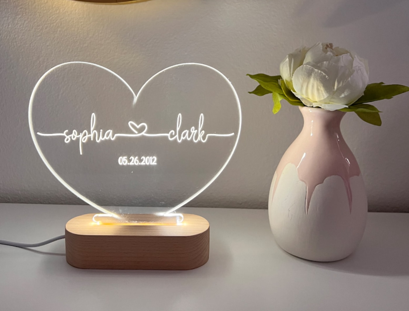 a light up heart with a flower in a vase